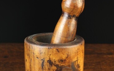 A 19th Century Turned Treen Pestle & Mortar. The pestle 6¾'' (17 cm) in length. The mortar on moulde