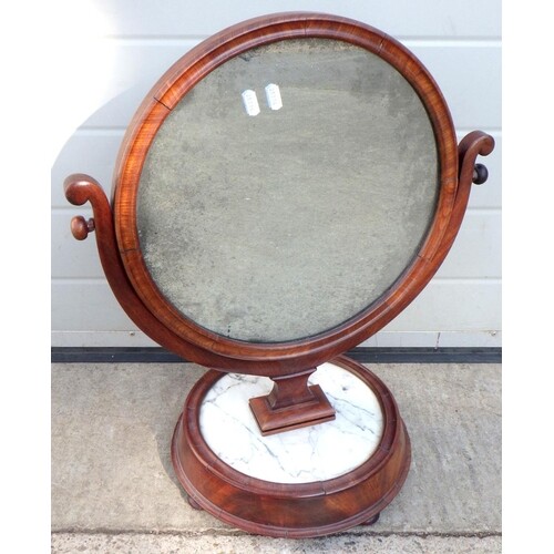 A 19th cen circular toilet mirror on a grey veined marble ba...