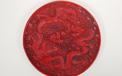A Chinese cinnabar lacquer style dish with raised twin...