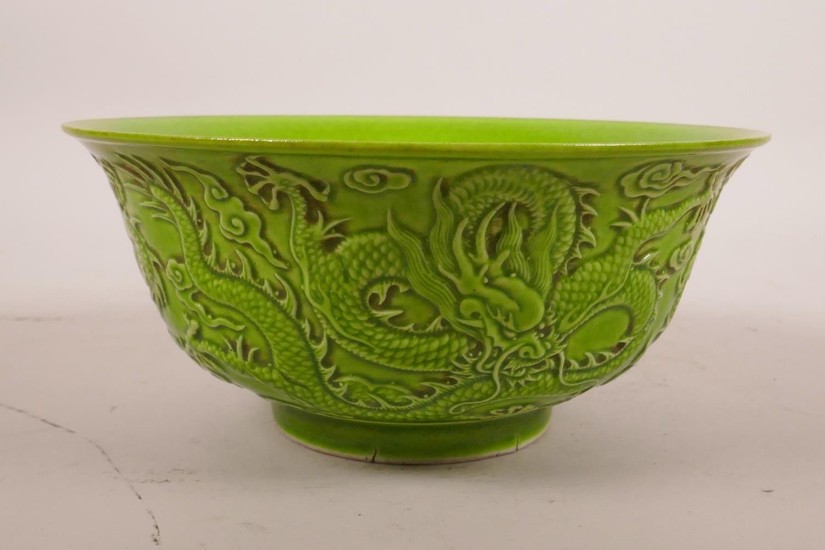 A Chinese green glazed porcelain bowl with raised dragon dec...