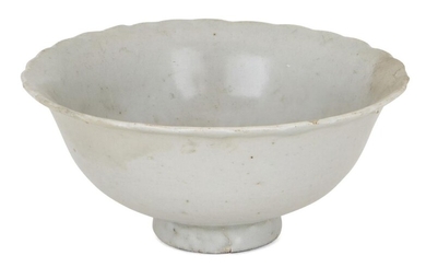 A Chinese porcelain white ware bowl, Song/Yuan dynasty, with foliate rim and moulded with vertical petals to the interior, 12cm diameter