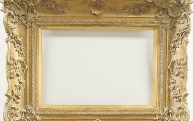 A Gilded Composition Louis XV Style Swept Frame, late 20th century, with cavetto sight, stiff leaf ogee course, sanded frieze, the plain hollow with foliate and flower head scrollwork, shell and cartouche centres and corners, schematic demi-fleur...