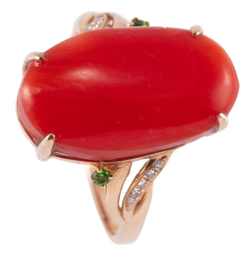 A VINTAGE 18CT GOLD CORAL RING; set with an 18.27 x 10.57mm cabochon coral to shoulders each set with a small green garnet and 5 sin...