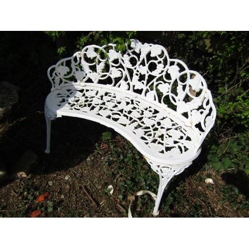 A cast iron garden bench of convex form with fruiting vine d...