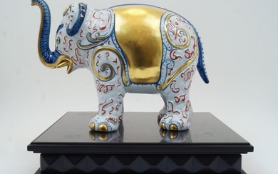 A modern Italian Manifattura Artistica le Porcellane model of an elephant, numbered 2405, retailed by Asprey, printed mark and gold paper label, on an associated rectangular ebonised composition plinth, the elephant - 27cm high, 37cm wide