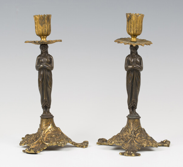 A pair of 19th century brown patinated and gilt bronze figural candlesticks, the classical female st