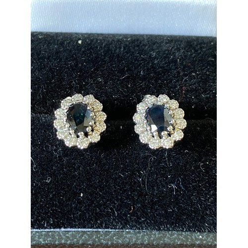 A pair of 9ct white gold earrings, each set with a sapphire ...