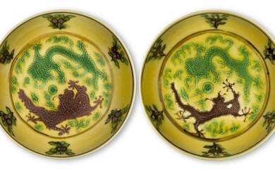 A pair of Chinese imperial porcelain small yellow ground saucer dishes, Guangxu marks and of the period, each incised in green and aubergine with two five-clawed dragons in pursuit of a flaming pearl amongst stylised flames and clouds, encircled by...