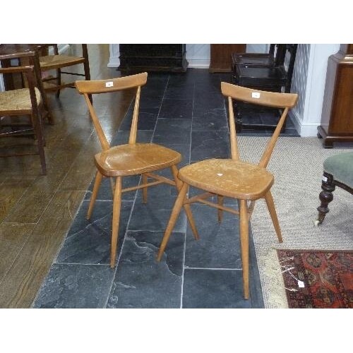 A pair of mid 20thC light elm and beech Ercol Stacking Chair...