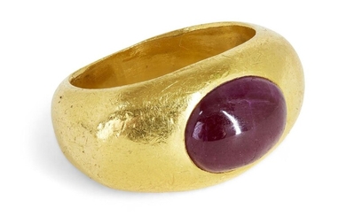 A ruby ring, in the Roman style the wide tapering band inset with an oval cabochon ruby, ring size L, unmarked