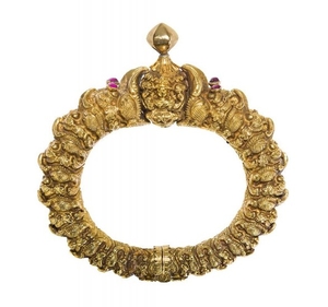 A ruby-set 'makara head' gold bracelet (Toda),...