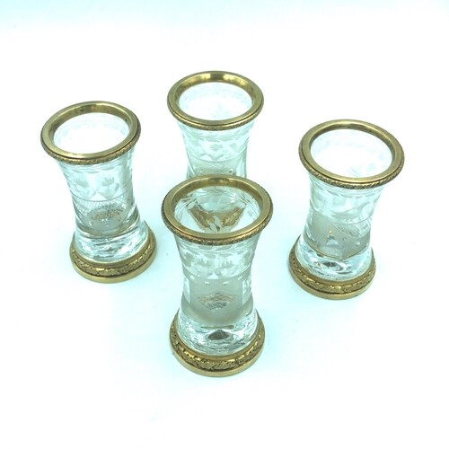 A set of four rock crystal and gilt metal shot glasses. The ...