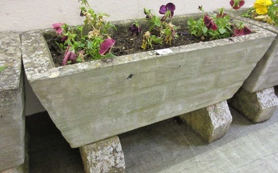A weathered rectangular stoneware planter with blocks and flowersCondition Report...