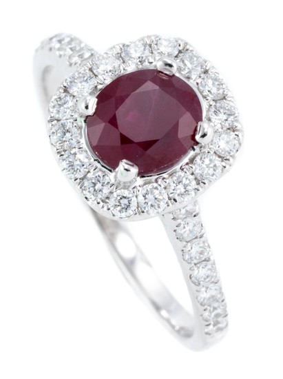 AN 18CT WHITE GOLD RUBY AND DIAMOND CLUSTER RING; centring an oval cut ruby of approx. 0.85ct to surround and shoulders set with 30...