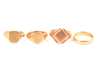 An 18 carat gold wedding ring and three gold signet rings.