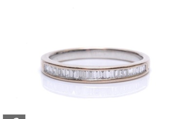 An 18ct hallmarked white gold diamond half eternity ring, co...