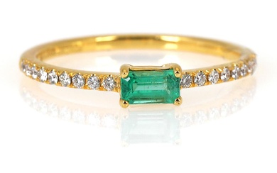 An emerald and diamond ring set with an emerald-cut emerald weighing app....