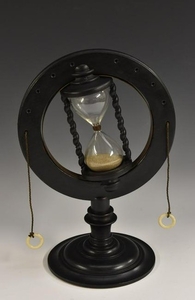 An unusual ebonised table top hour glass, the chamber