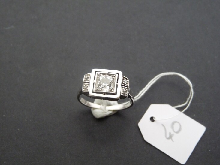 Bague Art Déco en or gris 18K (750/oo) centrée d'un diamant coussin taille ancienne calibrant...