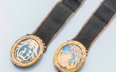 Pair of bracelets made of braided hair, decorated with oval medallions in pomponne, silver clasps (800 thousandths). The first one showing a dog at the foot of a tree in a cartouche on a blue enamel background. The second representing a stele with the...