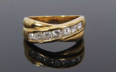Diamond ring with two cross-over bands and a row of seven channel set brilliant cut diamonds estimated to weigh approximately 0.70cts, ring size N½