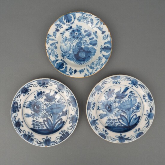 Drie Delfts aardewerk borden met blauw-witte bloemdecors, waaronder één...