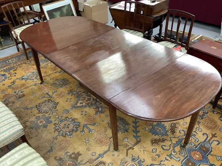 George III mahogany extending dining table, with D-shaped ends and central folding section, raised on square tapered legs and brass cappings and castors