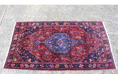 Handwoven red ground carpet, approx 240cm x 130cm