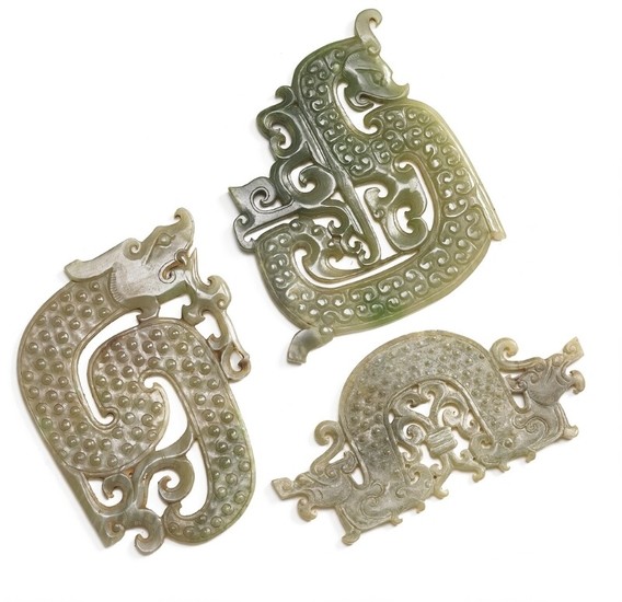 Three Chinese ornaments of greenish jade carved in the shape of dragons. Weight 309 g. L. 11–14 cm. H. 7–13 cm. (3)