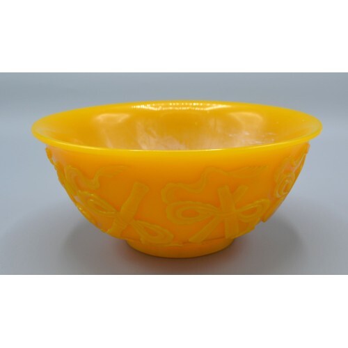 A Chinese Yellow Glass Bowl decorated in relief with impleme...
