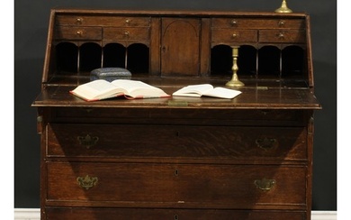 A George III oak bureau, fall front enclosing a fitted inter...
