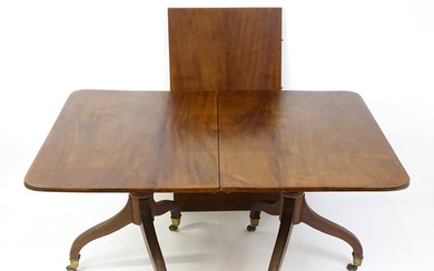 A Georgian mahogany double pedestal dining table raised on r...