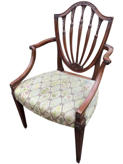 A Hepplewhite style mahogany open armchair with carved shield shaped...