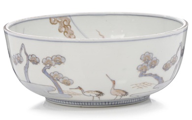 A Japanese porcelain bowl decorated in blue, sepia and gold with cranes....
