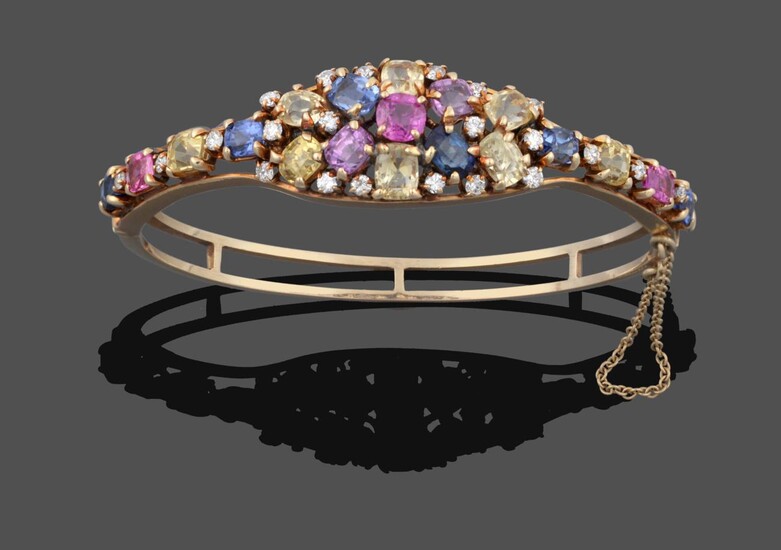 A Multi-Gemstone Cluster Bangle, the cluster set throughout with vari-shaped pink, blue, yellow and