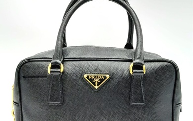 A Prada Black Bauletto Handbag. Saffiano leather exterior with...
