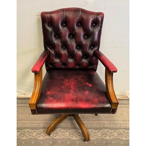 A RED LEATHER BUTTON BACK SWIVEL DESK CHAIR, on a wooden fra...