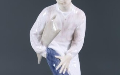 A Royal Copenhagen Porcelain Figure of a Butcher's Boy,...