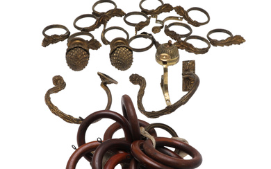 A SET OF 12 CAST AND GILT METAL CURTAIN RINGS, PAIR OF POLE END FINIALS, PAIR CAST TIEBACKS, AND WOODEN CURTAIN RINGS.