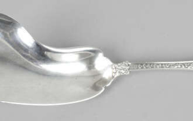 A Tiffany & Co sterling silver dolphin shaped crumber, in Olympian pattern.