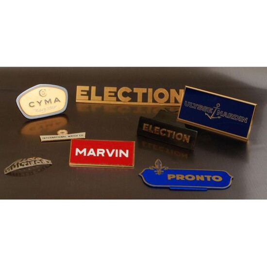 A batch of 8 vintage metallic/enamelled display cases of the following brands: Election(2), Ulysse Nardin(1), Mido(1), Marvin(1), IWC(1), Pronto(1), Cyma(1).