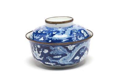 A blue and white porcelain covered bowl painted with dragon writhing amidst clouds on a blue ground