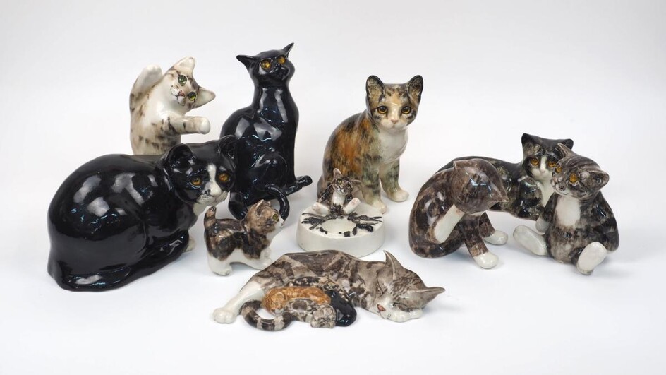 A collection of Winstanley pottery cats, to include an ashtray modelled as a cat sitting by a campfire, 12.5cm diameter, a sleeping cat group, 30cm long, and eight cats with glass eyes, tallest 24cm high (10)