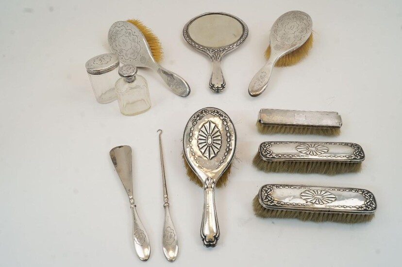 A group of silver mounted vanity items, comprising: a mirror and three matching brushes, with various dates Chester, 1911, Chester 1912, Birmingham 1913 and one with rubbed date marks; two matching hand brushes with floral engraving and initial...