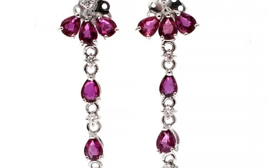 NOT SOLD. A pair of ear pendants each set with numerous pear-shaped rubies flanked by...