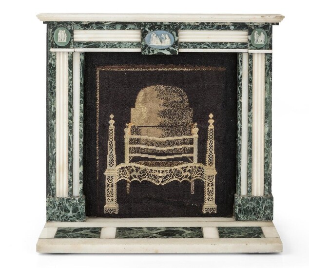 A verde antico and white marble model of a chimneypiece, of George III style, late 19th century, the frieze and jamb blocks mounted with jasperware style oval plaques, the opening inset with a needlework picture of a fire-grate, 28.5cm high, 32cm...