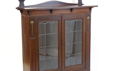An Art Nouveau mahogany cabinet with a shaped upstand and tw...
