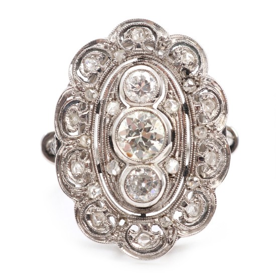 An Art déco diamond ring set with three old mine-cut diamonds and numerous smaller rose-cut diamonds, mounted in 18k white gold. Size 51. Circa 1920.
