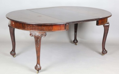 An early 20th century mahogany extending dining table, the circular top with single extra leaf, heig