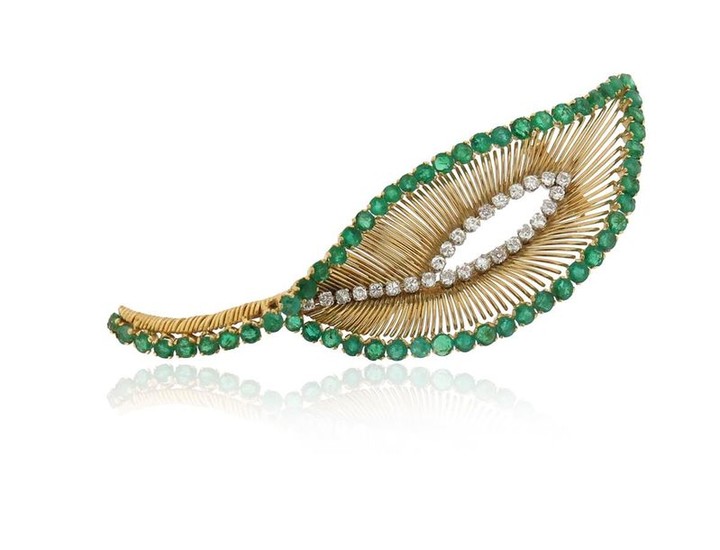 An emerald and diamond brooch, of leaf design,...